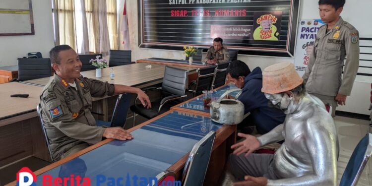 Petugas Satpol-PP tengah mewawancarai manusia silver yang tertangkap saat beraksi di Pacitan. (Foto: Diki Kurnia/BeritaPacitan)