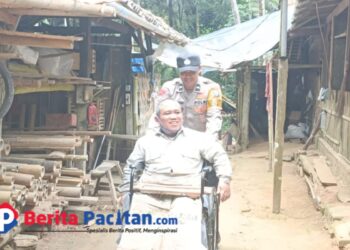 Aipda Latif tengah mendorong Wijayanto menuju rumahnya, Jumat, 10 Januari 2024. (Foto: Diki Kurnia/Beritapacitan)