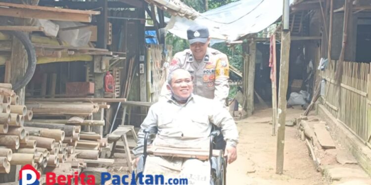 Aipda Latif tengah mendorong Wijayanto menuju rumahnya, Jumat, 10 Januari 2024. (Foto: Diki Kurnia/Beritapacitan)