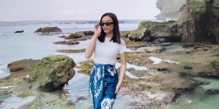 Wisatawan Nurul Permatasari saat berfoto di pinggiran Pantai Watu Karung Pacitan. (Foto: Nurul for Berita Pacitan)