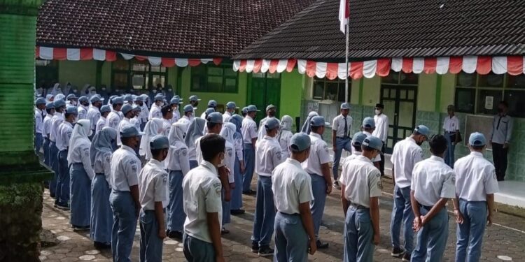 Siswa-siswi SMK Nurudh Dholam Kebonagung mengikuti upacara bendera di halaman sekolah. Mereka tampak mengikuti dengan penuh kedisiplinan dan semangat nasionalisme. Sebagai sekolah gratis berbasis pesantren, Nurudh Dholam tak hanya menanamkan ilmu pengetahuan, tapi juga karakter dan nilai-nilai kebangsaan sejak dini.(Foto: SMK for Beritapacitan)