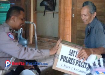 Polisi RW Wonogondo, IPDA Eko Bambang, membagikan paket sembako sebagai wujud nyata program Polres Pacitan 1 Hari 1 Kebaikan. (Foto: Sunardi / beritapacitan.com)
