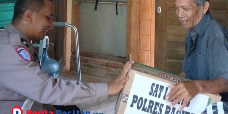 Polisi RW Wonogondo, IPDA Eko Bambang, membagikan paket sembako sebagai wujud nyata program Polres Pacitan 1 Hari 1 Kebaikan. (Foto: Sunardi / beritapacitan.com)