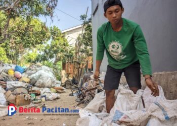Indra, pekerja harian pemilah rongsokan di Ploso, Pacitan. Meski kerja keras seharian, penghasilan yang didapat sering kali tak cukup untuk menutup kebutuhan rumah tangga.” (foto: Sunardi/Berita Pacitan)