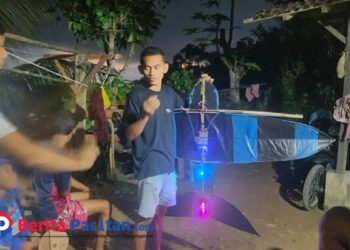 Pemuda di Desa Klesem, Kecamatan Kebonagung, tengah merakit layangan malam berlampu warna-warni. Tradisi musim angin ini tidak hanya menjadi hiburan, tetapi juga sarana mempererat kebersamaan lintas generasi di Pacitan. (Foto: Sunardi Berita Pacitan).