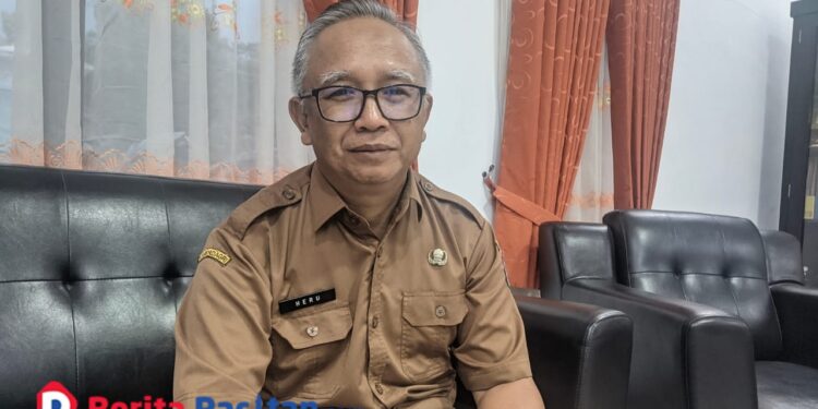 Heru Tunggul, Kepala Dinas Perumahan, Kawasan Permukiman, dan Pertanahan (Perkimtan) Kabupaten Pacitan, saat ditemui di kantornya menjelaskan kendala pembangunan jalan lingkungan akibat cuaca ekstrem. (Foto: Sunardi/Berita Pacitan).