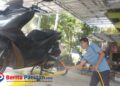 Seorang pekerja mencuci sepeda motor pelanggan di layanan cucian motor dan mobil milik Choirul Anam di Jalan Cut Mutia No. 01, Kelurahan Ploso, Pacitan, Senin, 19 Januari 2026. (Foto: Sunardi/Beritapacitan.com)