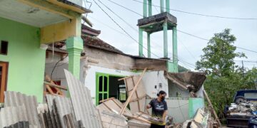 Tatapan lesu tak menghalangi warga untuk mulai membersihkan sisa material bangunan yang hancur setelah gempa tektonik M 6,2 mengguncang wilayah Pacitan, Jumat 6/2/2026. (Foto : Heri Nur for Berita Pacitan).