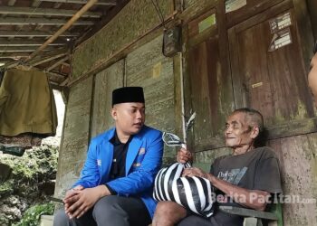 Kader PMII Pacitan menyerahkan bantuan kepada Ponijan (76), warga Desa Plubungan, Kecamatan Kebonagung, yang hidup sebatang kara di rumah sederhana. (Foto : Dok. Pmii Pacitan).