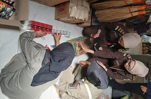 Petugas gabungan dari Satpol PP, Bea Cukai, Kejaksaan, dan Kepolisian melakukan pemeriksaan di sejumlah toko dan kios di Kecamatan Bandar, Pacitan, dalam operasi pemberantasan rokok ilegal, Rabu (10/6/2026).