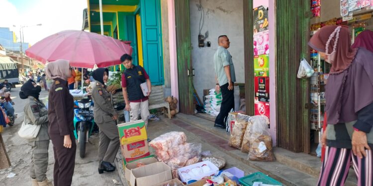 Petugas gabungan dari Satpol PP, Bea Cukai, Kejaksaan, dan Kepolisian melakukan pemeriksaan di sejumlah toko dan kios di Kecamatan Bandar, Pacitan, dalam operasi pemberantasan rokok ilegal, Rabu (10/6/2026).