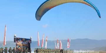 Prajurit Yonif Teritorial Pembangunan (TP) 934/Satria Buwana Yudha menampilkan demonstrasi paralayang saat upacara penutupan latihan paralayang di kawasan Pantai Pancer Door, Pacitan. (Foto: Sunardi / BeritaPacitan.com).